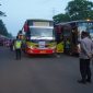 Petugas kepolisian melakukan pengamanan dan pengawasan pemberangkatan massa buruh menggunakan bus menuju Jakarta dalam rangka peringatan May Day.