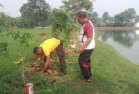 Personel Polsek Pasar Kemis melakukan penanaman pohon rambutan di area Kampung Waru, Desa Sukaharja, Kecamatan Sindang Jaya, Kabupaten Tangerang.