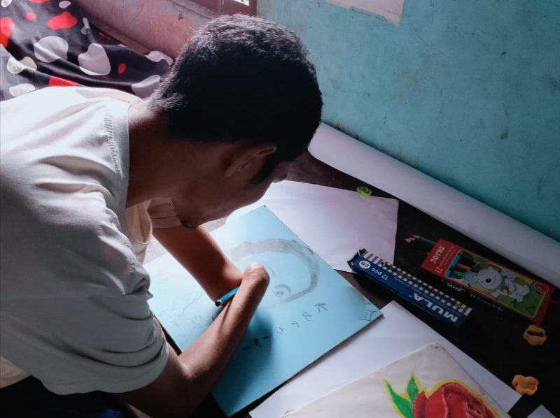 Di sebuah sudut sederhana Kampung Boradho, Desa Boradho, Kecamatan Bajawa, Kabupaten Ngada, seorang pemuda menantang keterbatasan dengan cara yang sunyi namun luar biasa. Namanya Rinto Moti. Ia lahir tanpa kedua kaki, tetapi dari jepitan tangannya lahir lukisan-lukisan yang mampu membuat orang terdiam haru. (Foto: Suru Oktaviano)