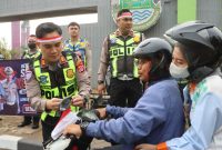 Anggota Polresta Tangerang membagikan bendera Merah Putih sekaligus memberikan edukasi tertib lalu lintas kepada pengendara di Lampu Merah Jalan Baru, Cikupa, Kabupaten Tangerang. (Dok. Humas Polresta Tangerang)