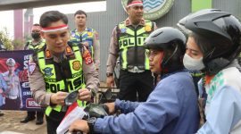 Anggota Polresta Tangerang membagikan bendera Merah Putih sekaligus memberikan edukasi tertib lalu lintas kepada pengendara di Lampu Merah Jalan Baru, Cikupa, Kabupaten Tangerang. (Dok. Humas Polresta Tangerang) 