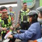 Anggota Polresta Tangerang membagikan bendera Merah Putih sekaligus memberikan edukasi tertib lalu lintas kepada pengendara di Lampu Merah Jalan Baru, Cikupa, Kabupaten Tangerang. (Dok. Humas Polresta Tangerang) 