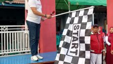 Lurah Kutabumi Ade Sunaryo membuka kegiatan jalan sehat RW 017 dengan mengibarkan bendera start.
