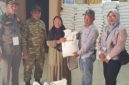Lurah Pakuhaji Uci Sanusi (tengah) berbaur dan berfoto bersama warga penerima manfaat di sela-sela kegiatan penyaluran bansos beras di Kantor Kelurahan Pakuhaji, Kabupaten Tangerang. (Dok. Dadang). 