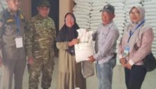 Lurah Pakuhaji Uci Sanusi (tengah) berbaur dan berfoto bersama warga penerima manfaat di sela-sela kegiatan penyaluran bansos beras di Kantor Kelurahan Pakuhaji, Kabupaten Tangerang. (Dok. Dadang).