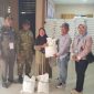 Lurah Pakuhaji Uci Sanusi (tengah) berbaur dan berfoto bersama warga penerima manfaat di sela-sela kegiatan penyaluran bansos beras di Kantor Kelurahan Pakuhaji, Kabupaten Tangerang. (Dok. Dadang). 