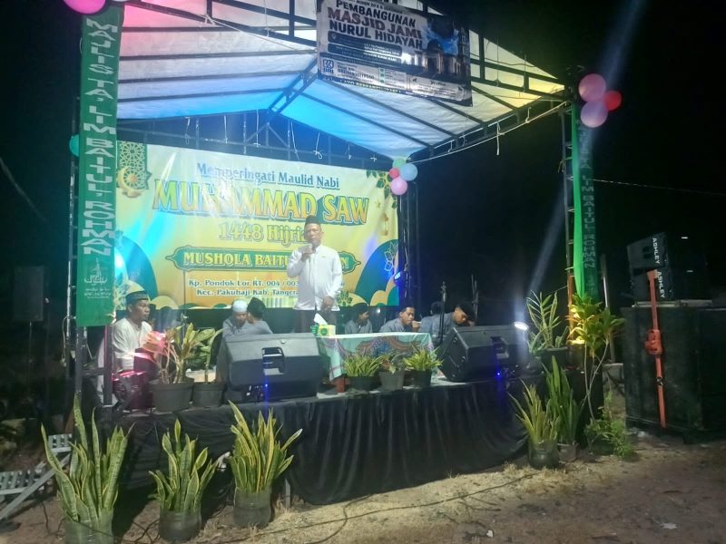 Lurah Pakuhaji Uci Sanusi (tengah) menghadiri Peringatan Maulid Nabi Besar Muhammad SAW bersama penceramah Kiai Sapu Jagat dan warga di Kampung Pondok Lor, Pakuhaji, Kabupaten Tangerang. (Dok. Dadang). 