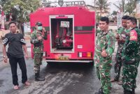 Alexander Salembun, jurnalis Metrosiar (kiri), bersama personel TNI AD di lokasi kegiatan pembersihan abu vulkanik menggunakan mobil water tank TNI AD.