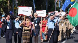 Peserta Parade IAWP 2026 dari berbagai negara berjalan dalam iring-iringan dengan membawa papan nama negara dan mengenakan seragam serta pakaian tradisional masing-masing. Parade berlangsung di kawasan Lapangan Puputan Renon, Denpasar, Bali.